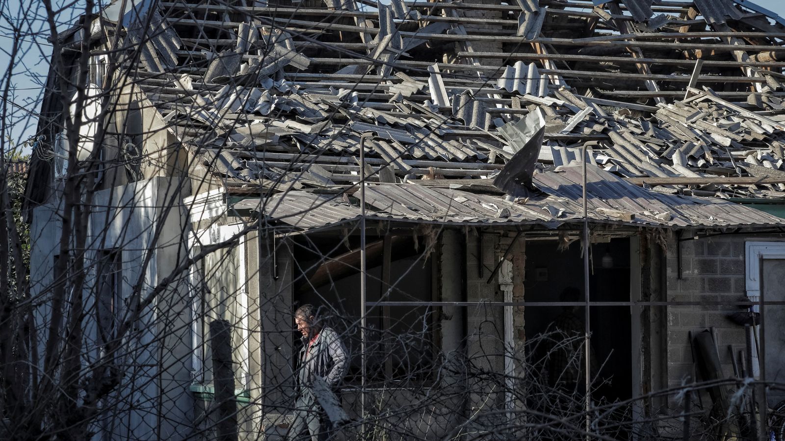 Un home a les restes d'una casa en la zona atacada per Rússia