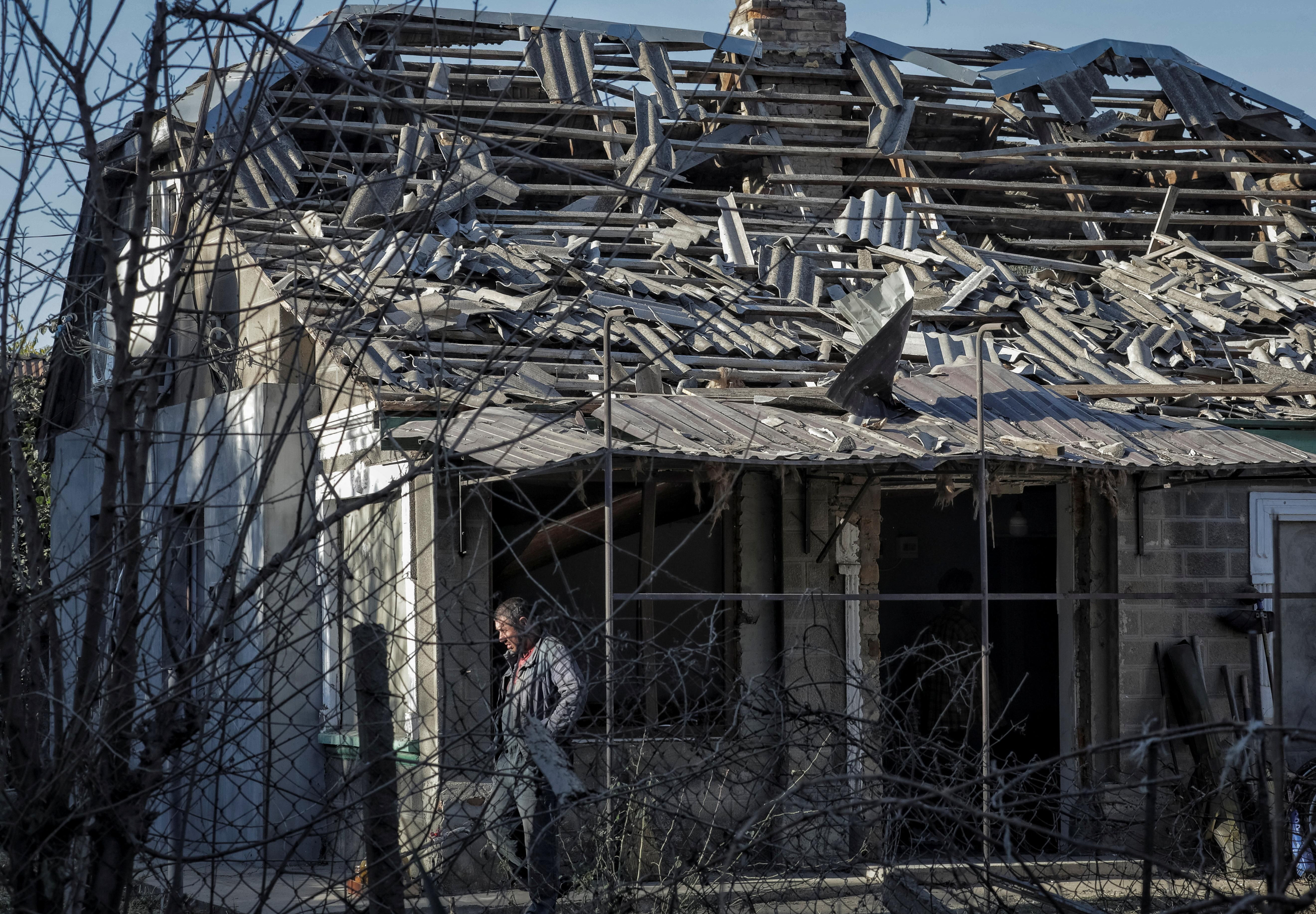 Un home a les restes d'una casa en la zona atacada per Rússia