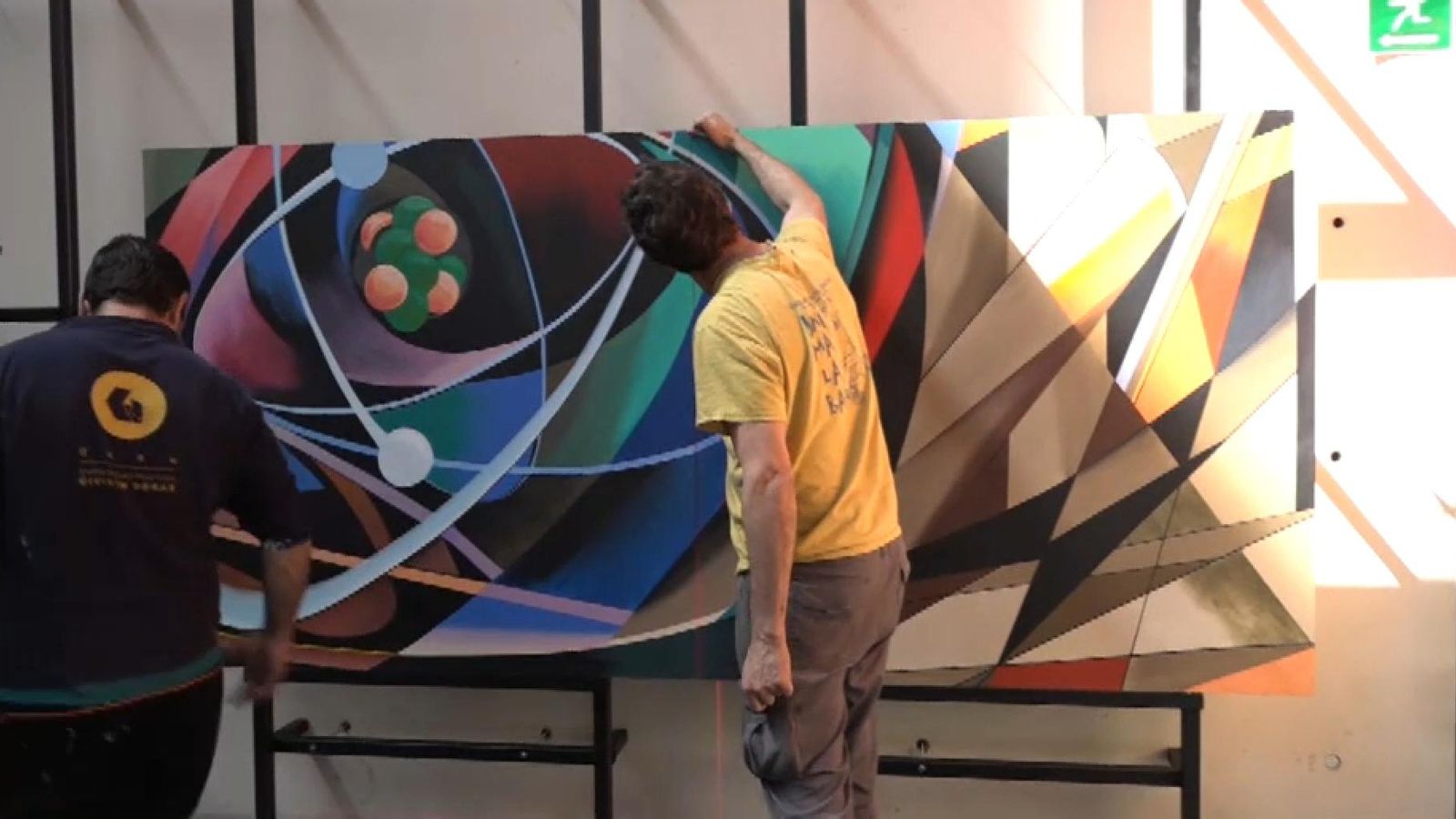 Diversos operaris instal·len el mural de Renau, que ha sigut traslladat per peces, a l'auditori castellonenc