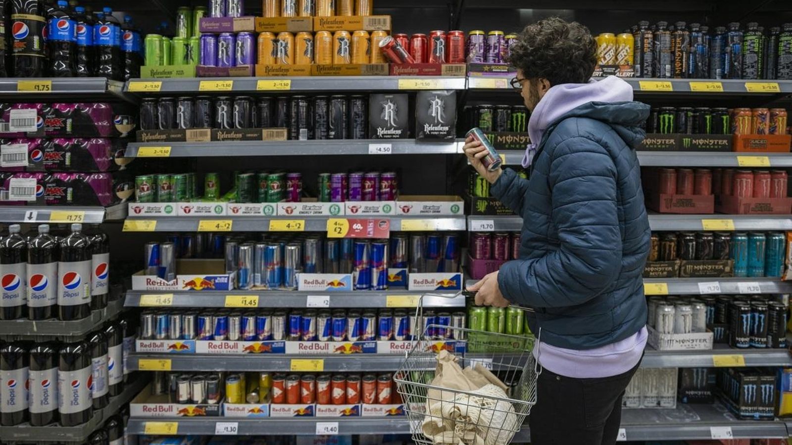 Un jove mira la secció de begudes energètiques en el supermercat
