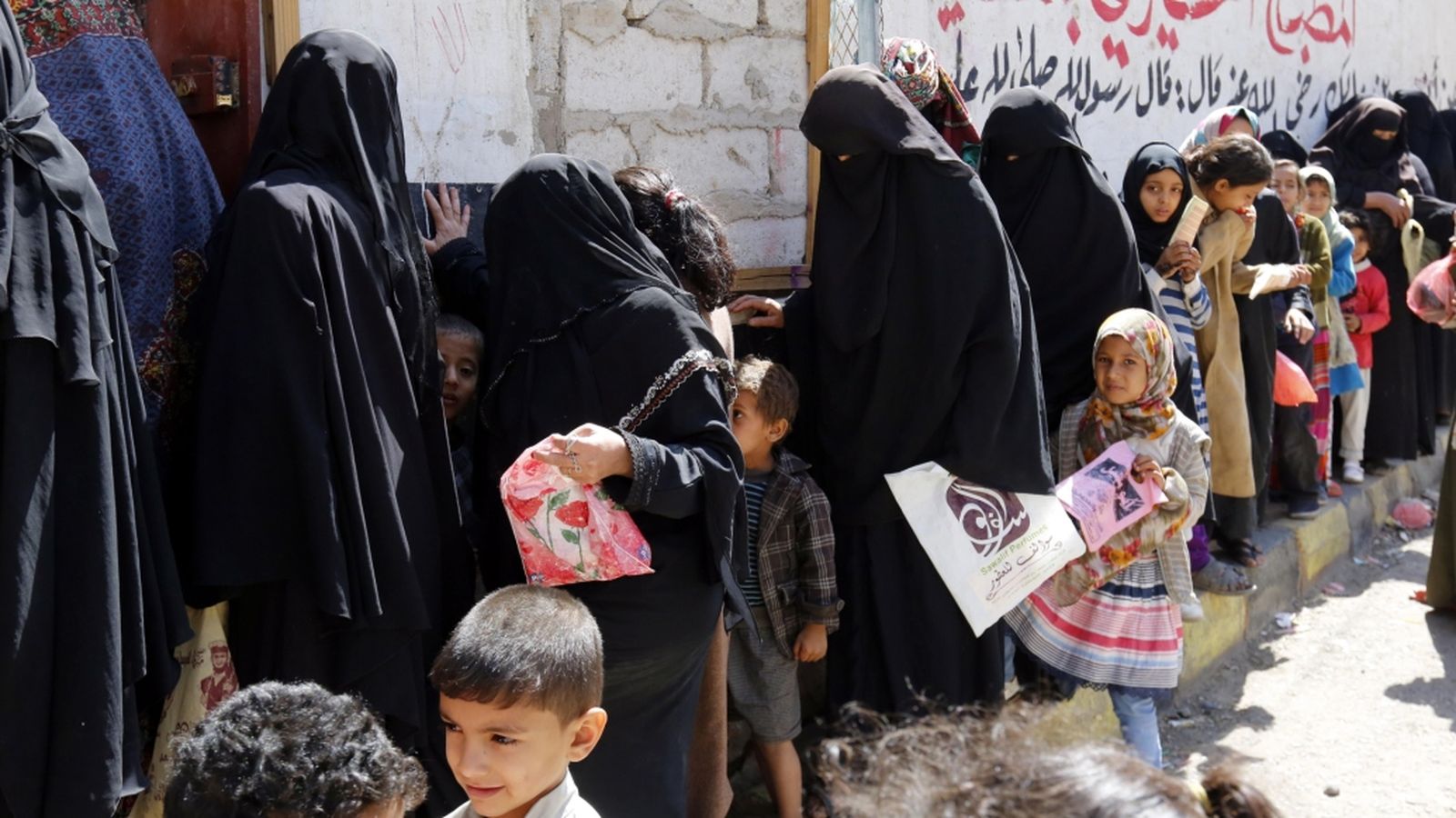 Xiquetes, xiquets i dones fan cua a Sanà per rebre la ració de menjar