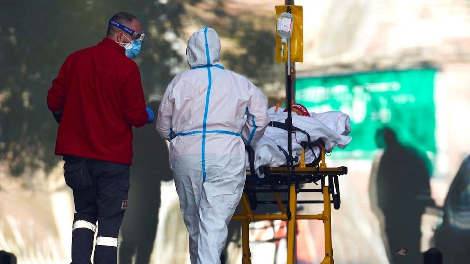 Uns sanitaris traslladen un pacient de coronavirus