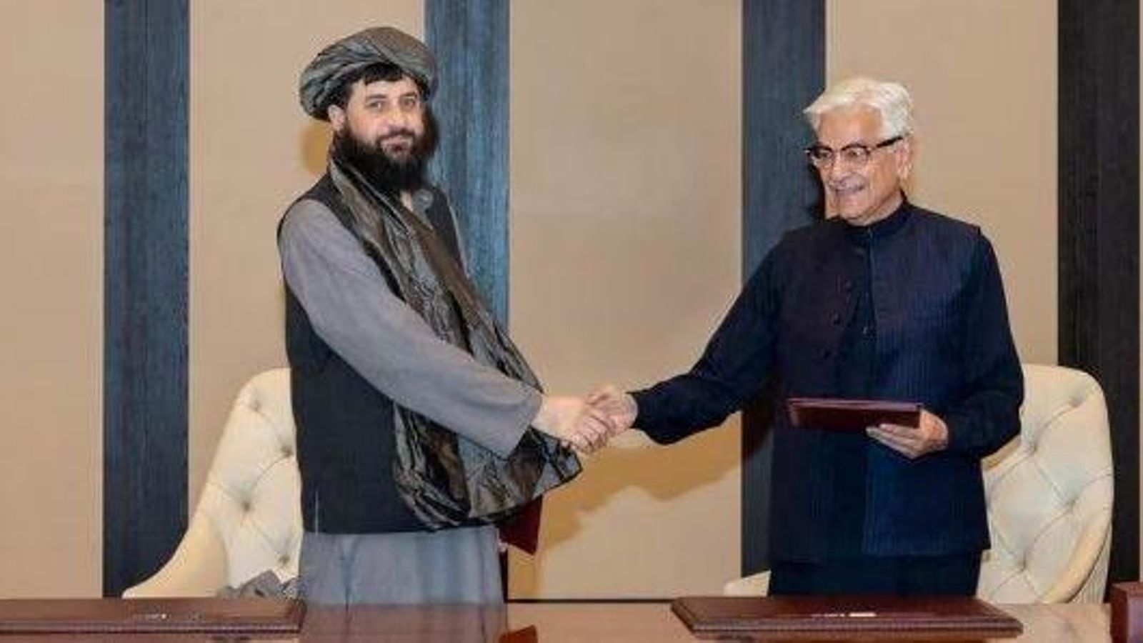 Els ministres de Defensa afganés, el mul·là Mohammad Yaqoob Mujahid, i pakistanés, Khawaja Muhammad Asif, es donen la mà després de la signatura d’un acord d’alto el foc a Doha (Qatar),