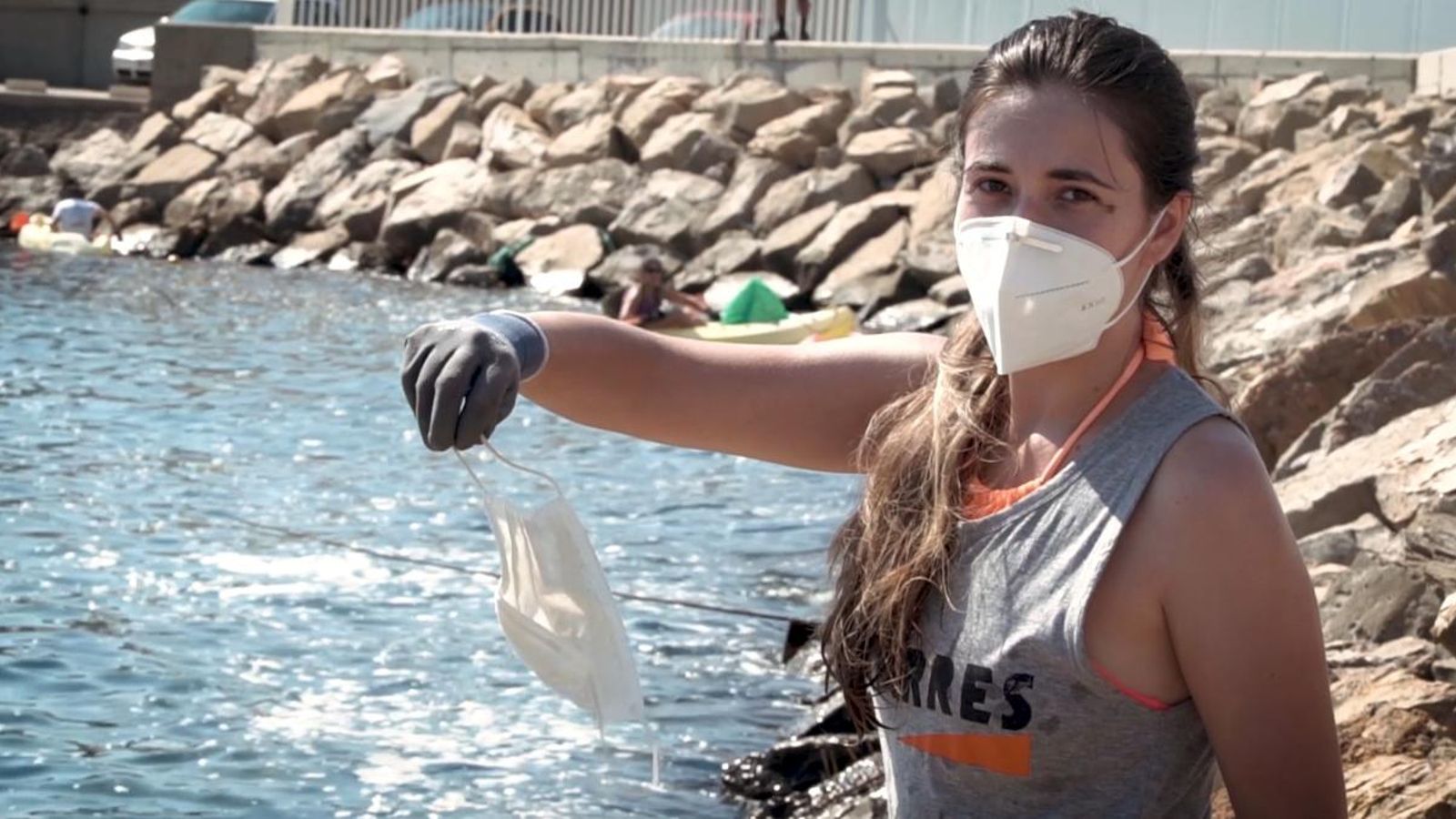 Una voluntària troba una mascareta a la platja.