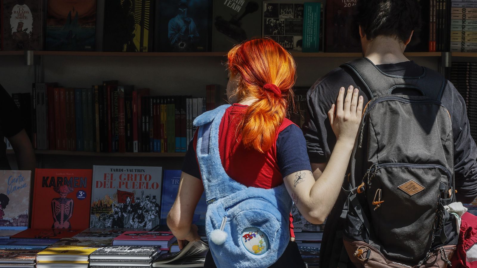 Dos joves miren una parada a la fira del Llibre de València, en arxiu