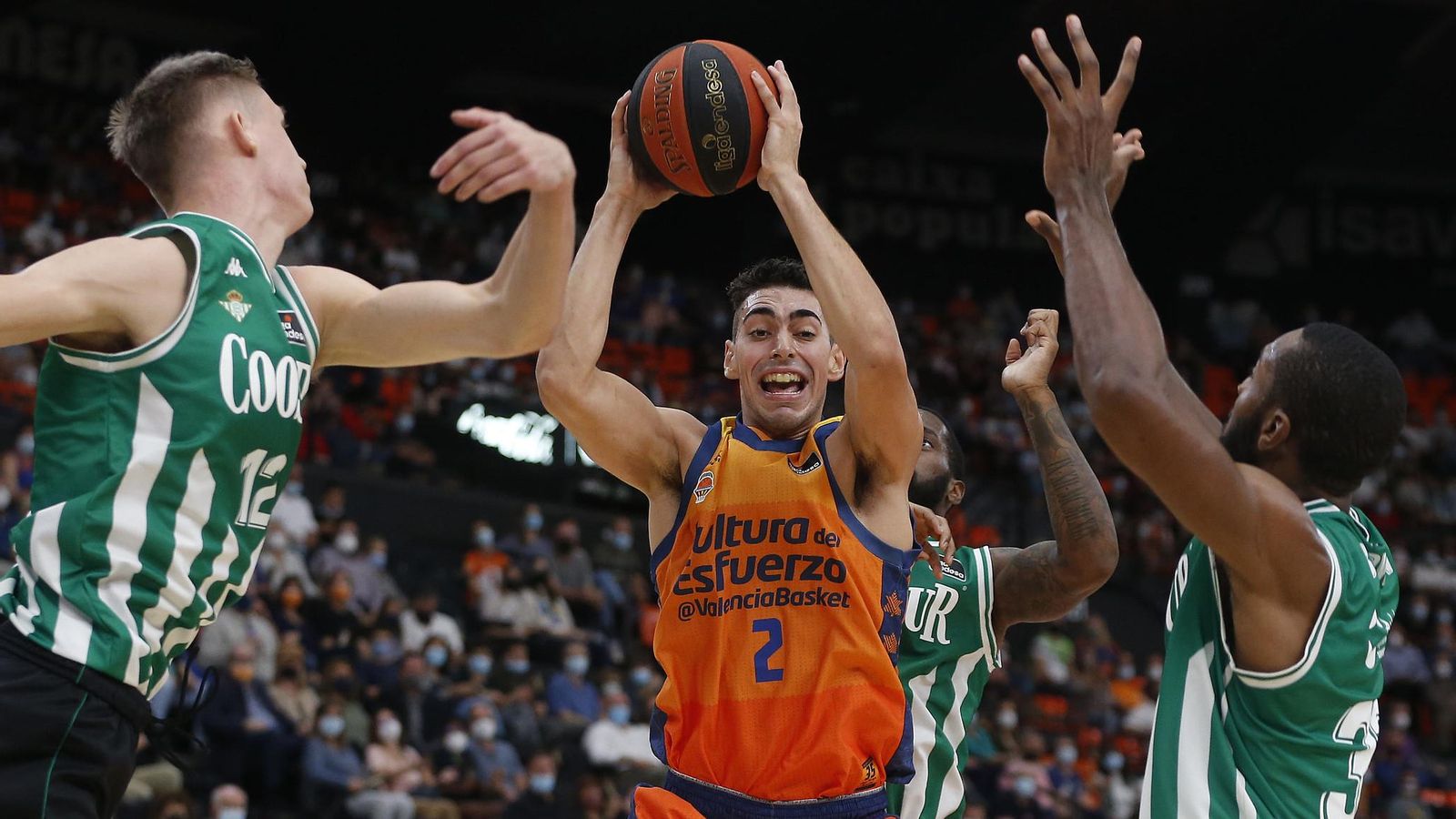 El taronja Josep Puerto s'eleva davant la defensa de tres jugadors del Betis