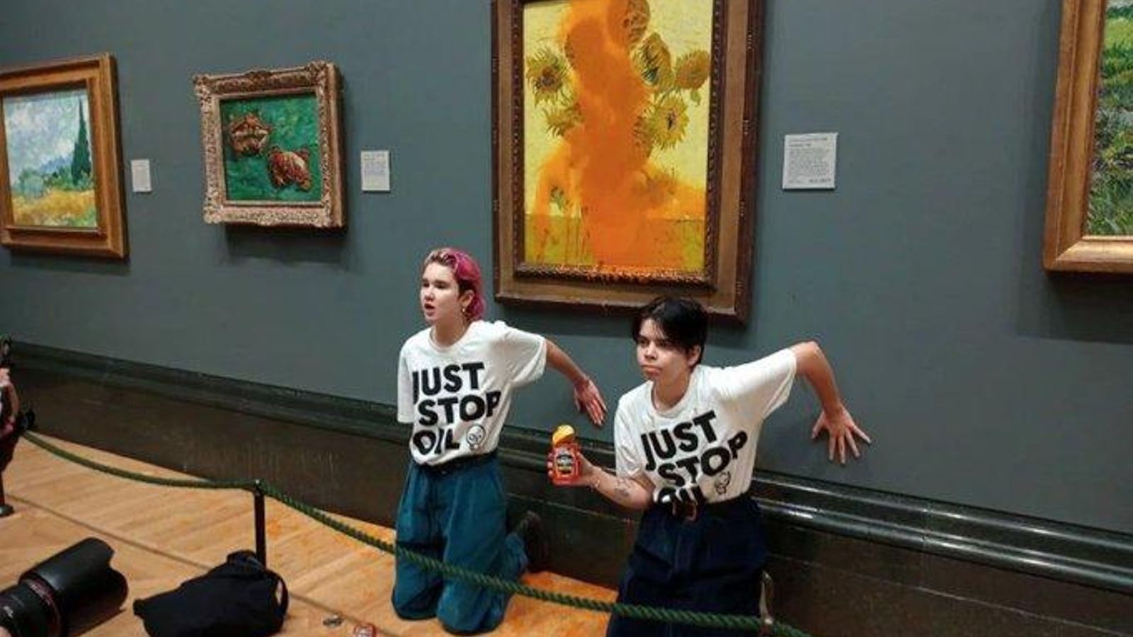 Les dos activistes davant del quadre dels Gira-sols de Van Gogh atacat, en la National Gallery de Londres