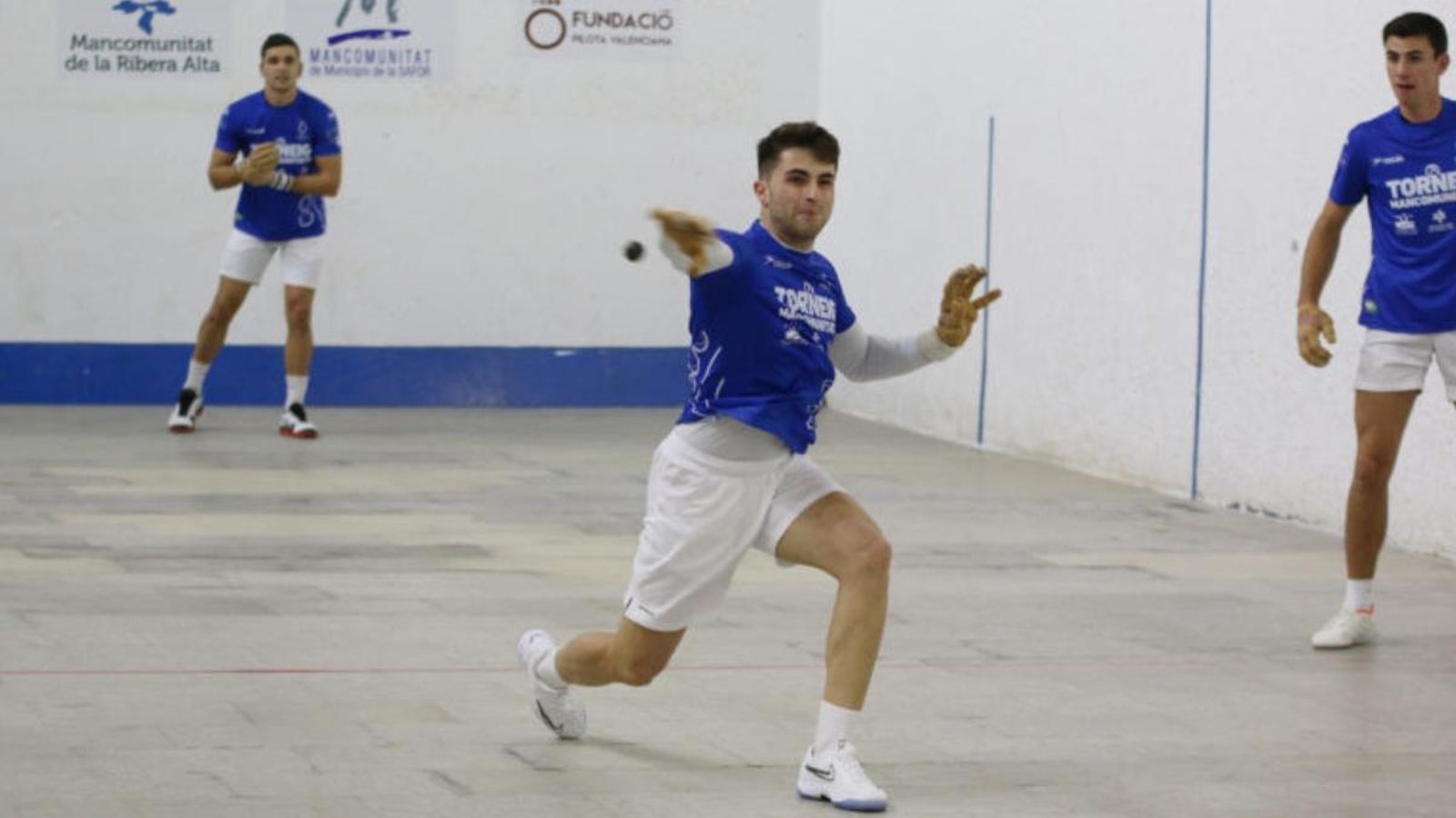 Raül colpeja la pilota amb la mirada atenta de Tonet i Ximo (darrere)