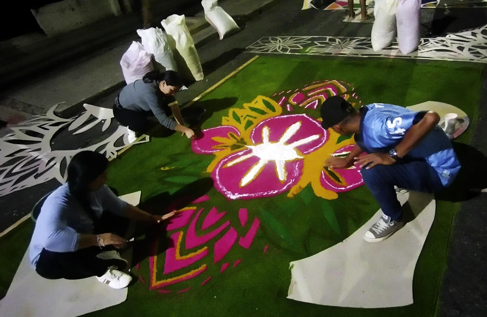 Diverses persones elaboren una catifa de serradures per a la commemoració del Via Crucis de Divendres Sant (6 d'abril de 2023)