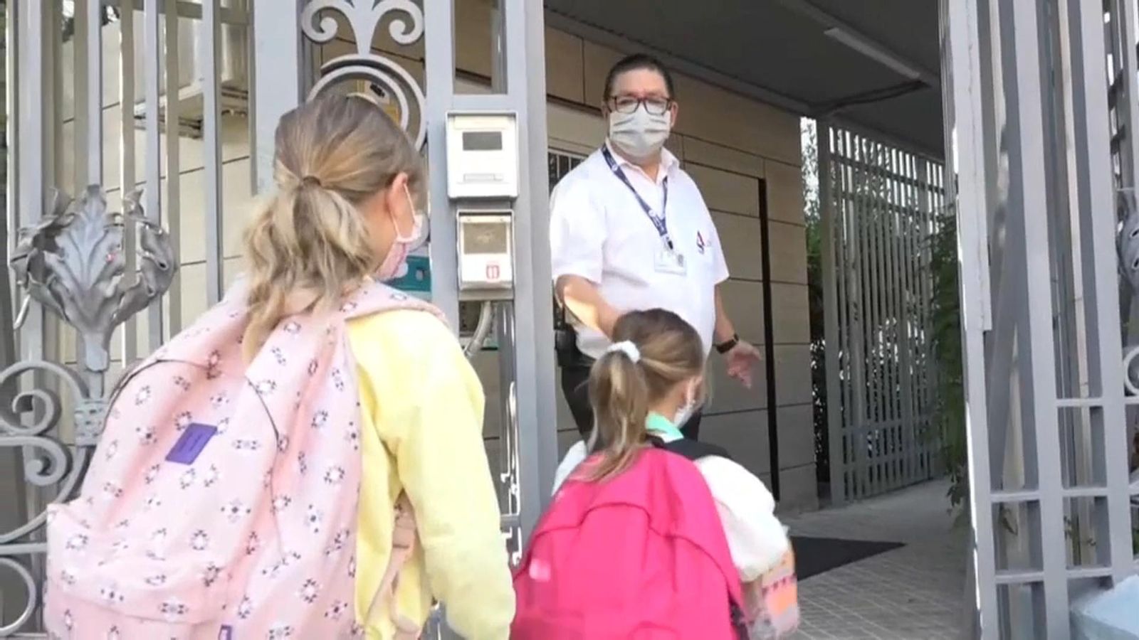 Dues xiquetes amb mascareta entren a un centre escolar
