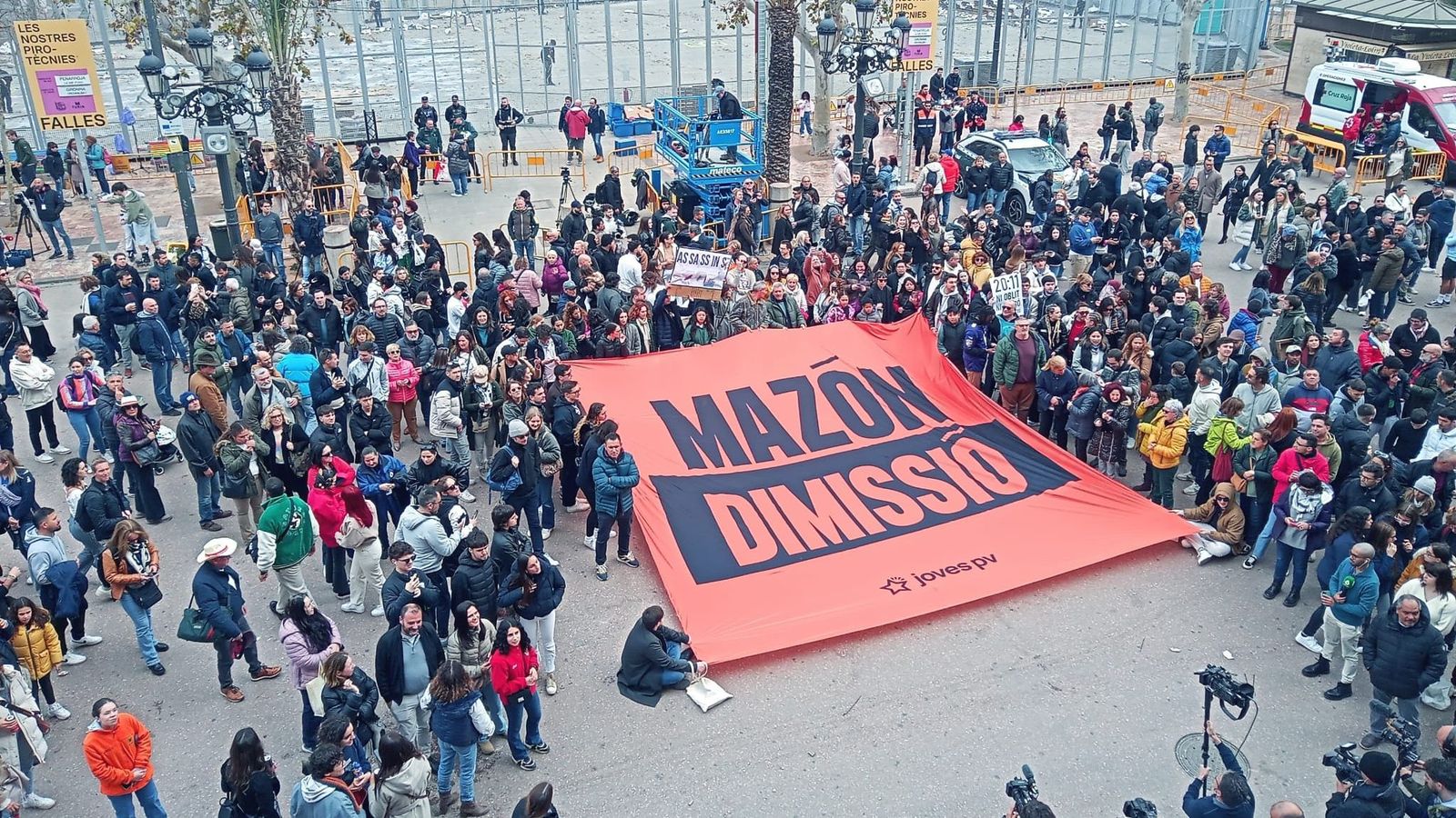Diverses persones despleguen un cartell dirigit al president de la Generalitat després de la mascletà