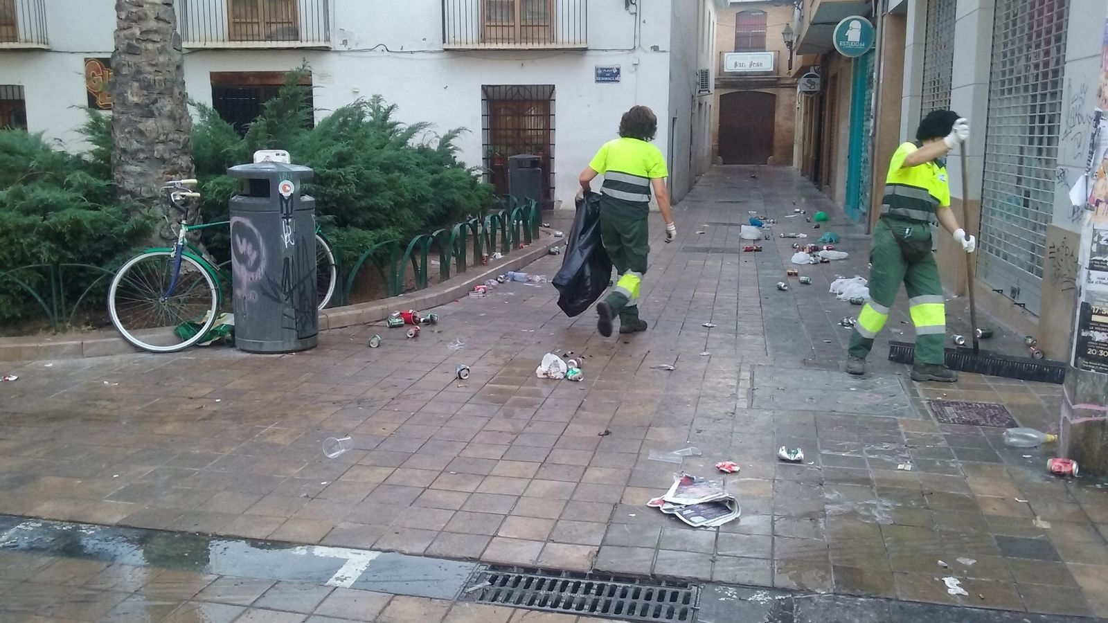 Treballadores municipals netejen les restes d'un botellot al barri de Benimaclet (València)