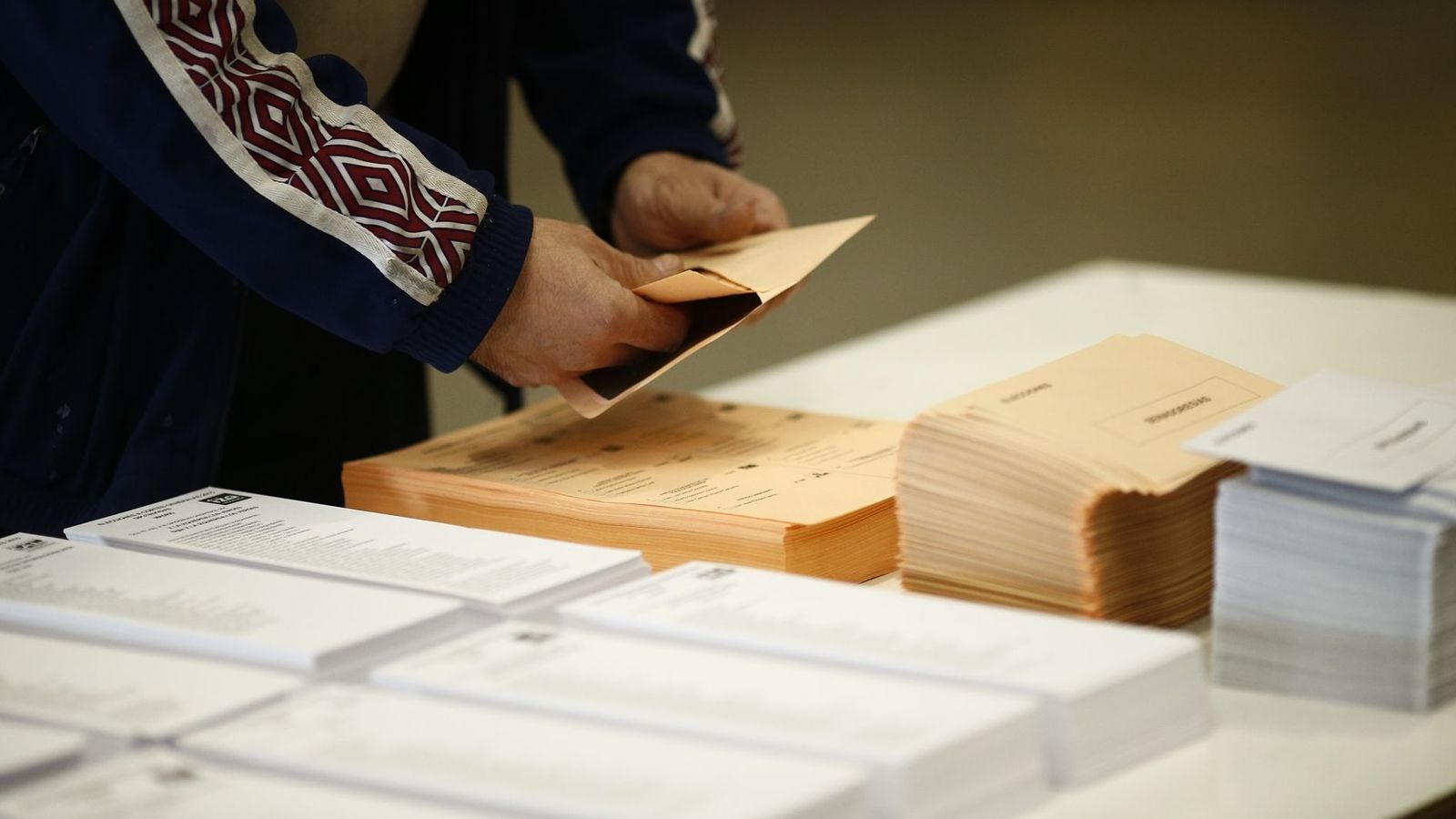 Un home prepara el seu vot al Senat amb la papereta color salmó