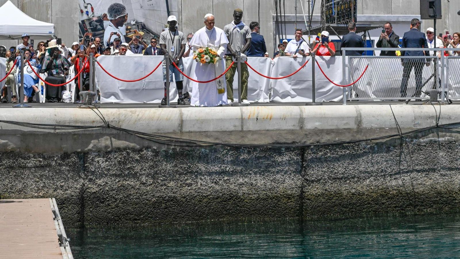 El papa sosté el ram de flors que ha llançat a la mar al port d’Arguineguín, a Gran Canària, en homenatge a tots els que han perdut la vida tractant d'arribar a Europa
