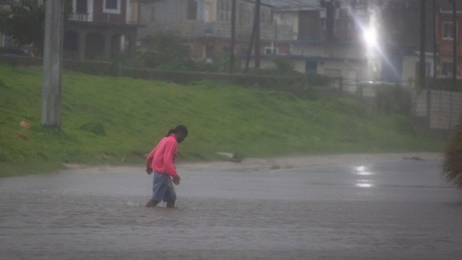 Un home camina per un carrer inundat mentre l'huracà Beryl assota la costa sud de l'illa, a Kingston, Jamaica