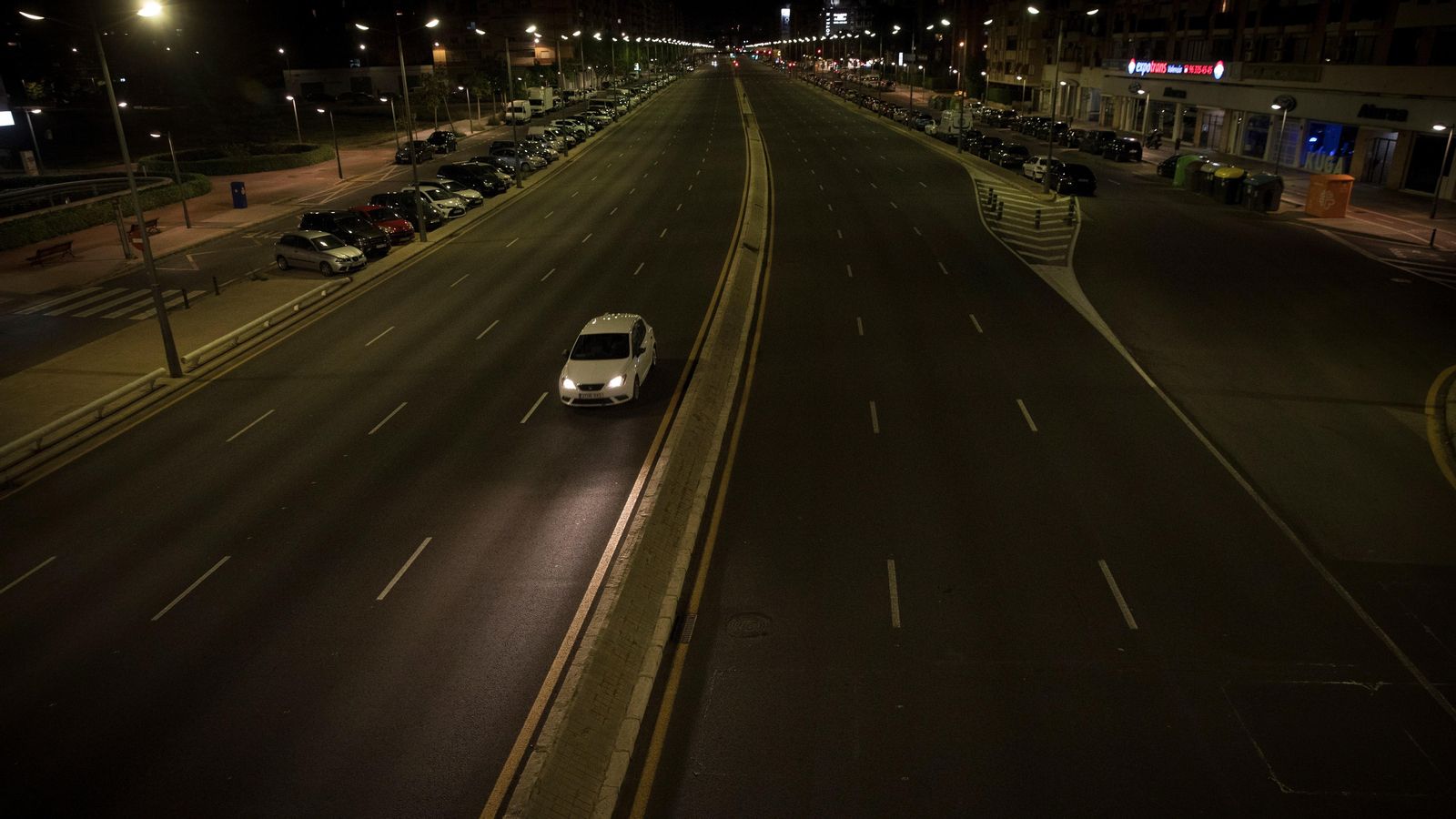 Un cotxe circula per una avinguda de València després de les deu de la nit, quan ja estava decretat el toc de queda