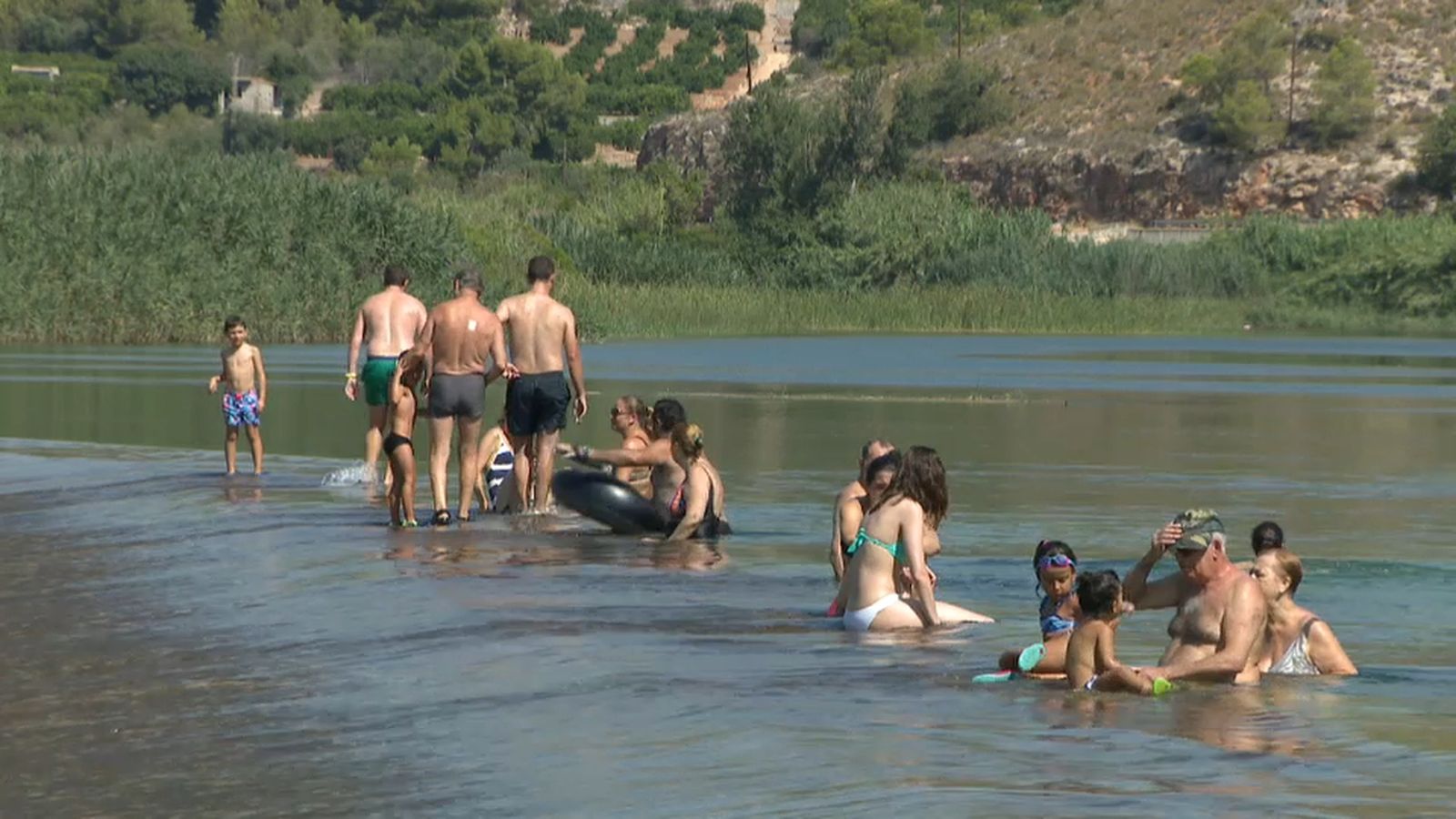 Banyistes refrescant-se a l'assut d'Antella