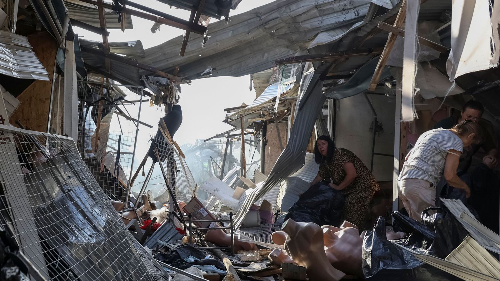 Diverses persones tracten de recuperar alguns objectes de la galeria comercial atacada per Rússia