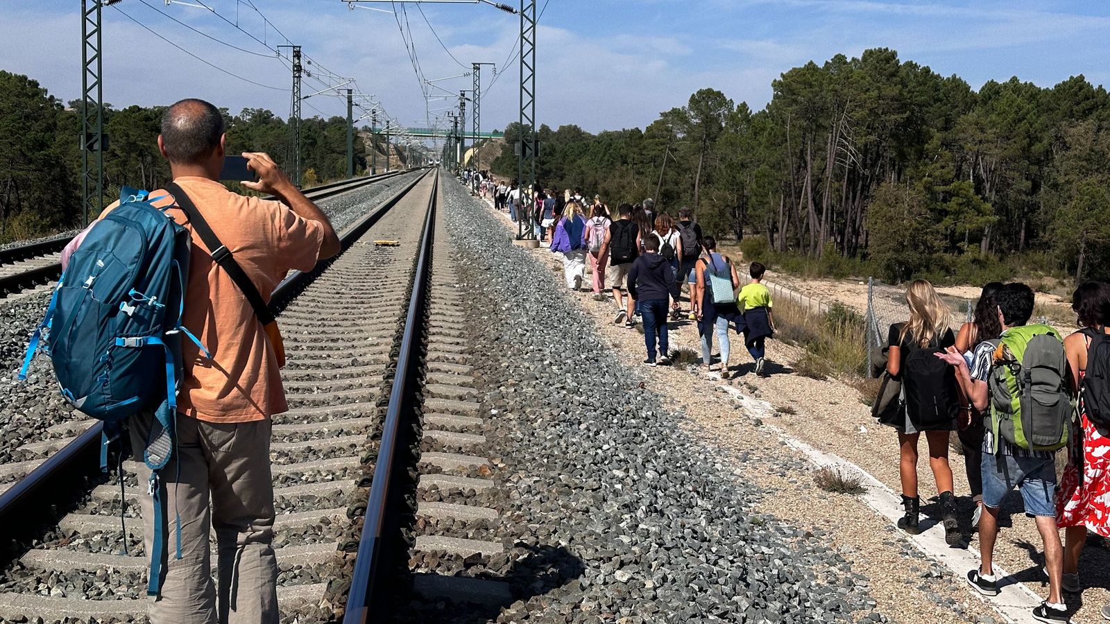 Fila de passatgers d'un dels trens avariats que es dirigeixen als autobusos fletats per Renfe