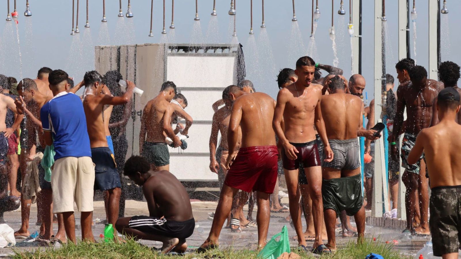 Migrants es dutxen en la platja d'El Trampolín este dissabte