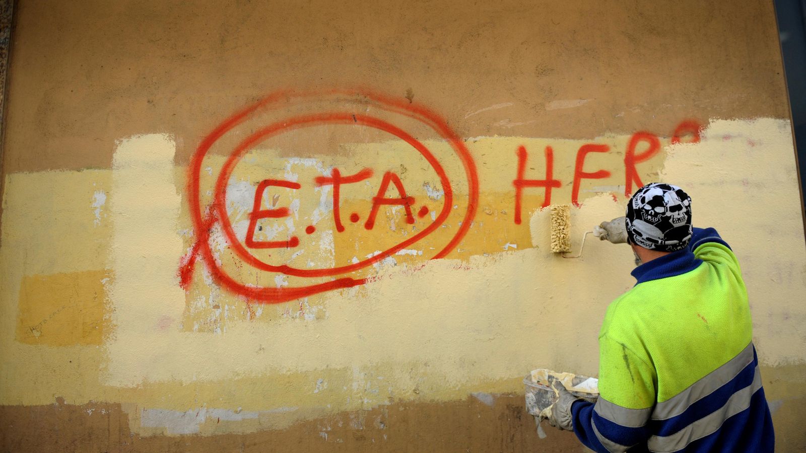 Un treballador esborra una pintada d'ETA