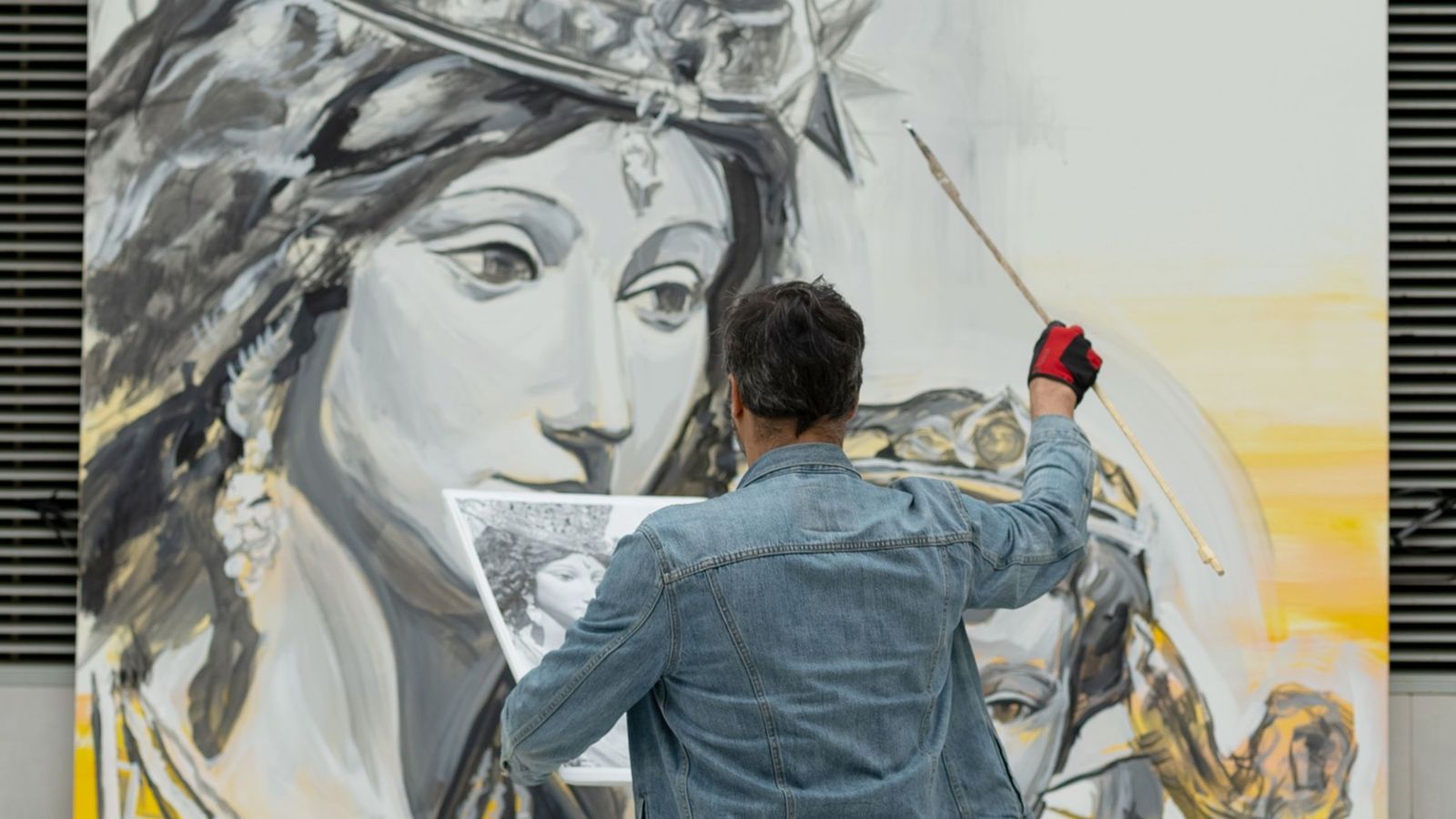 L'artista Luis Lonjedo davant un altre mural dedicat a la Mare de Déu que va pintar l'any passat