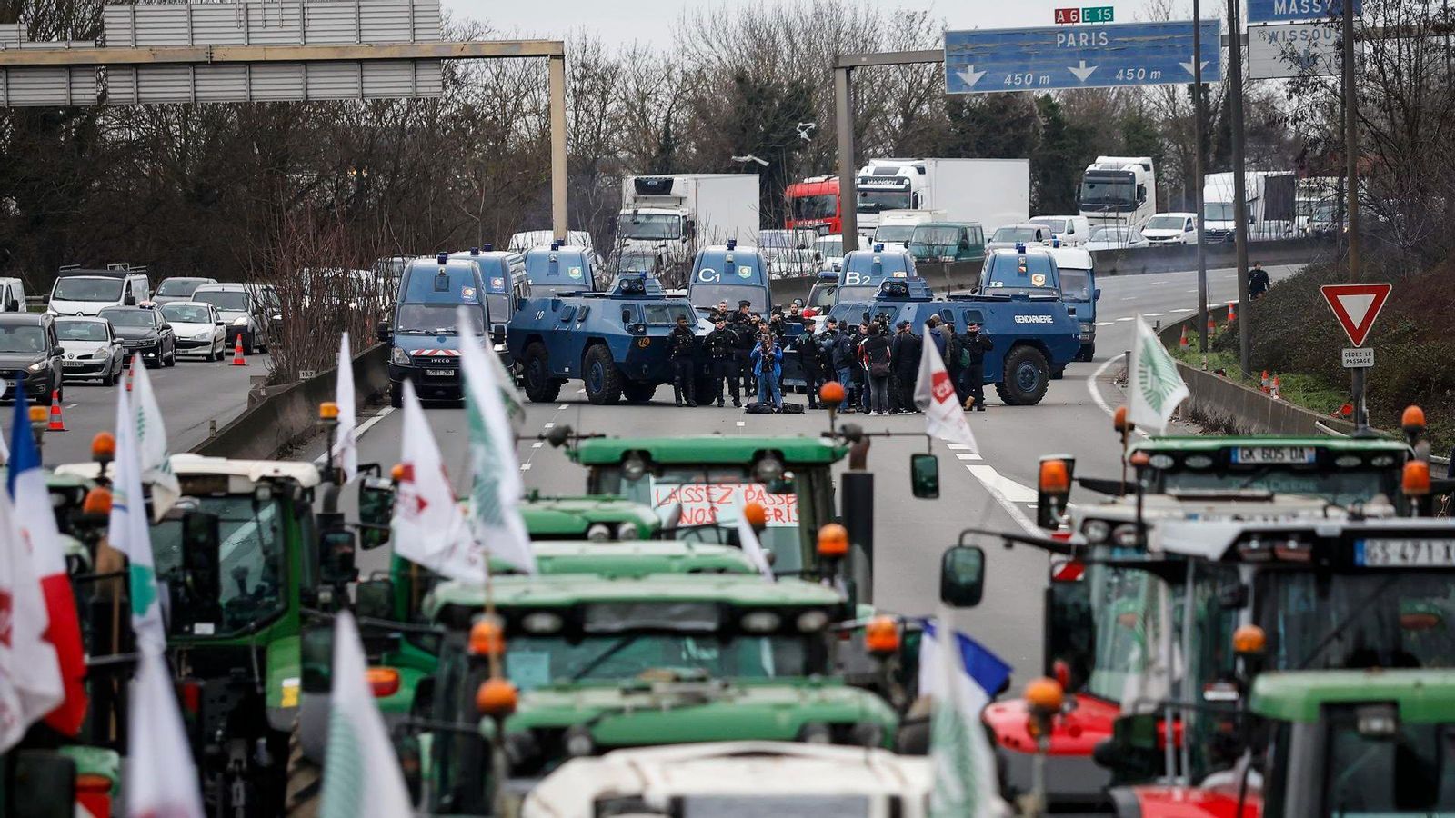 Una tractorada de llauradors francesos bloqueja l'autopista A-6, prop de Paría, front als agents de policia que els tallen el pas en una imatge d'aquest dimecres