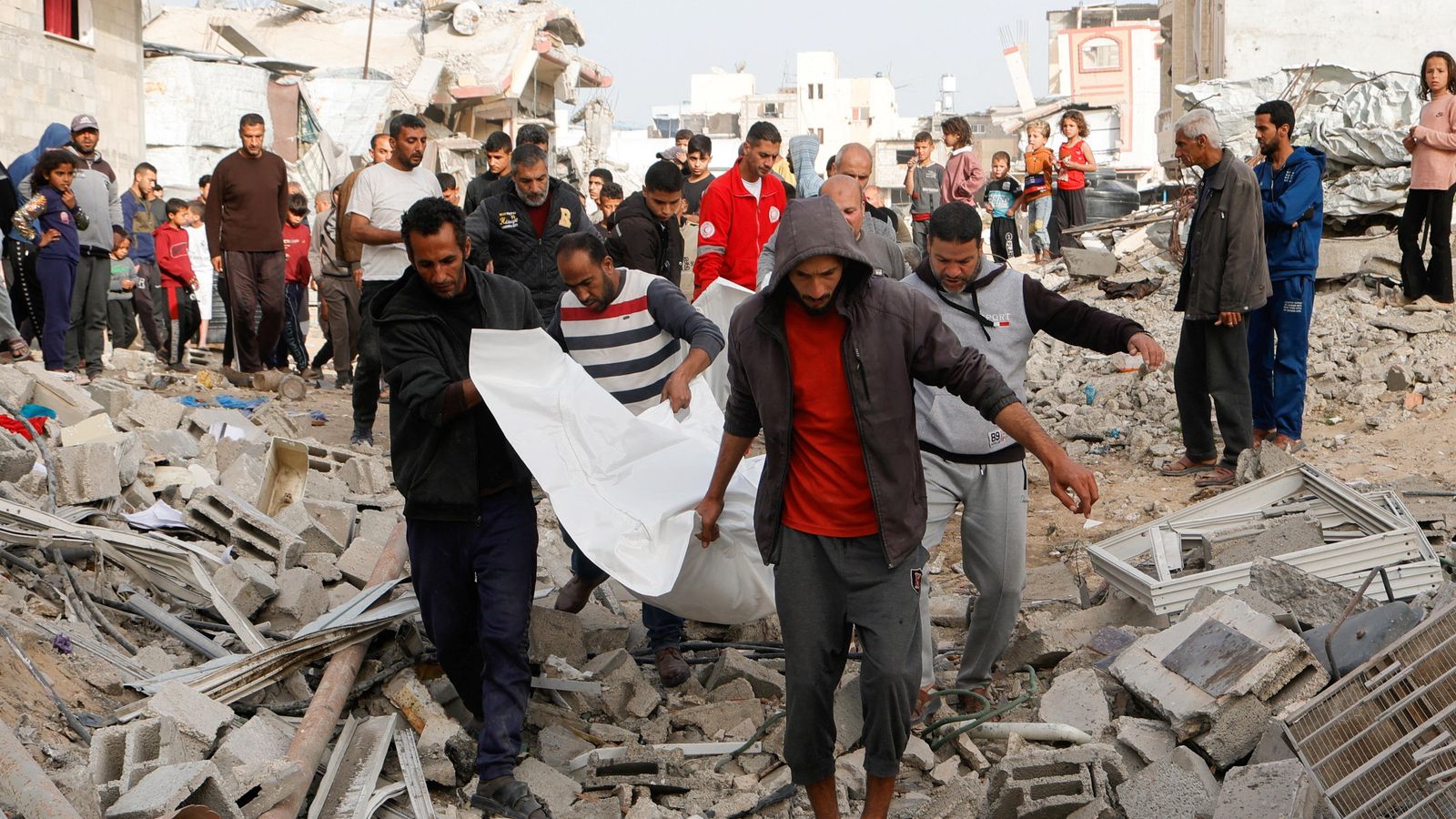 Gazians carreguen amb un cadàver recuperat entre els enderrocs, a Khan Younis