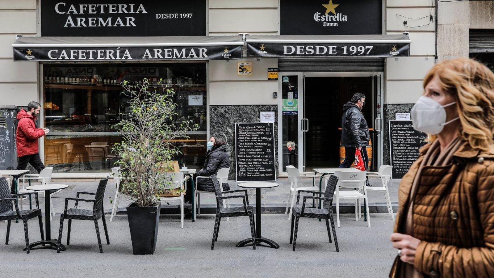 Una dona camina en front d'una terrassa al centre de València