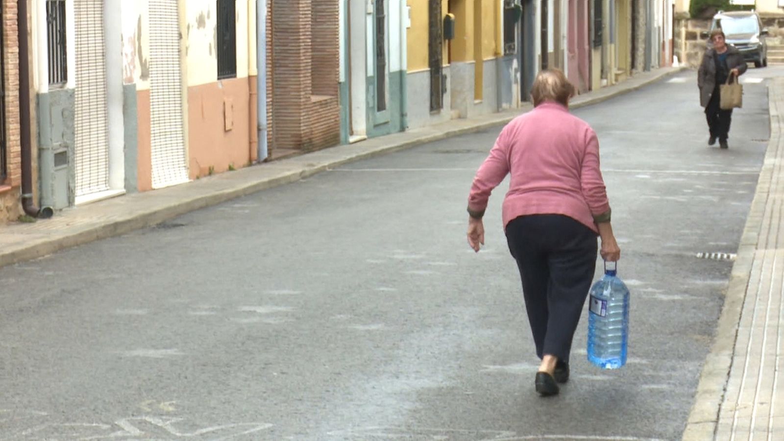 Una veïna de Campell, carregada amb l'aigua que ha arreplegat de la font