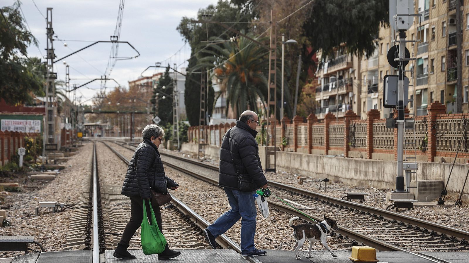 Dos persones creuen el passe a nivell d'Alfafar