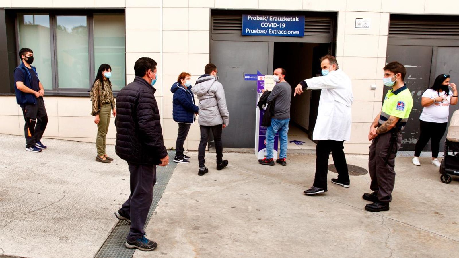 Un grup de veïns del barri de Sansomendi, a Vitòria, espera a les portes d'un centre de salut per a fer-se la prova PCR