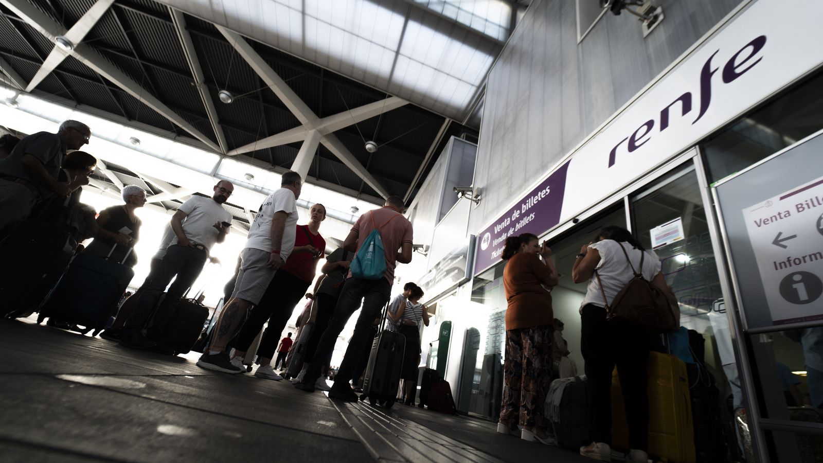 Un grup de persones fa cua davant el mostrador de venda de billets de Renfe, en una imatge d'arxiu