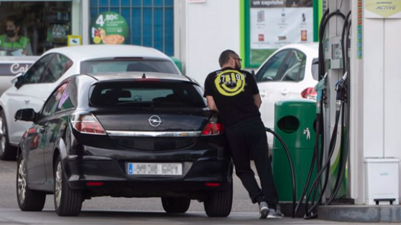 Un home reposta combustible en una gasolinera