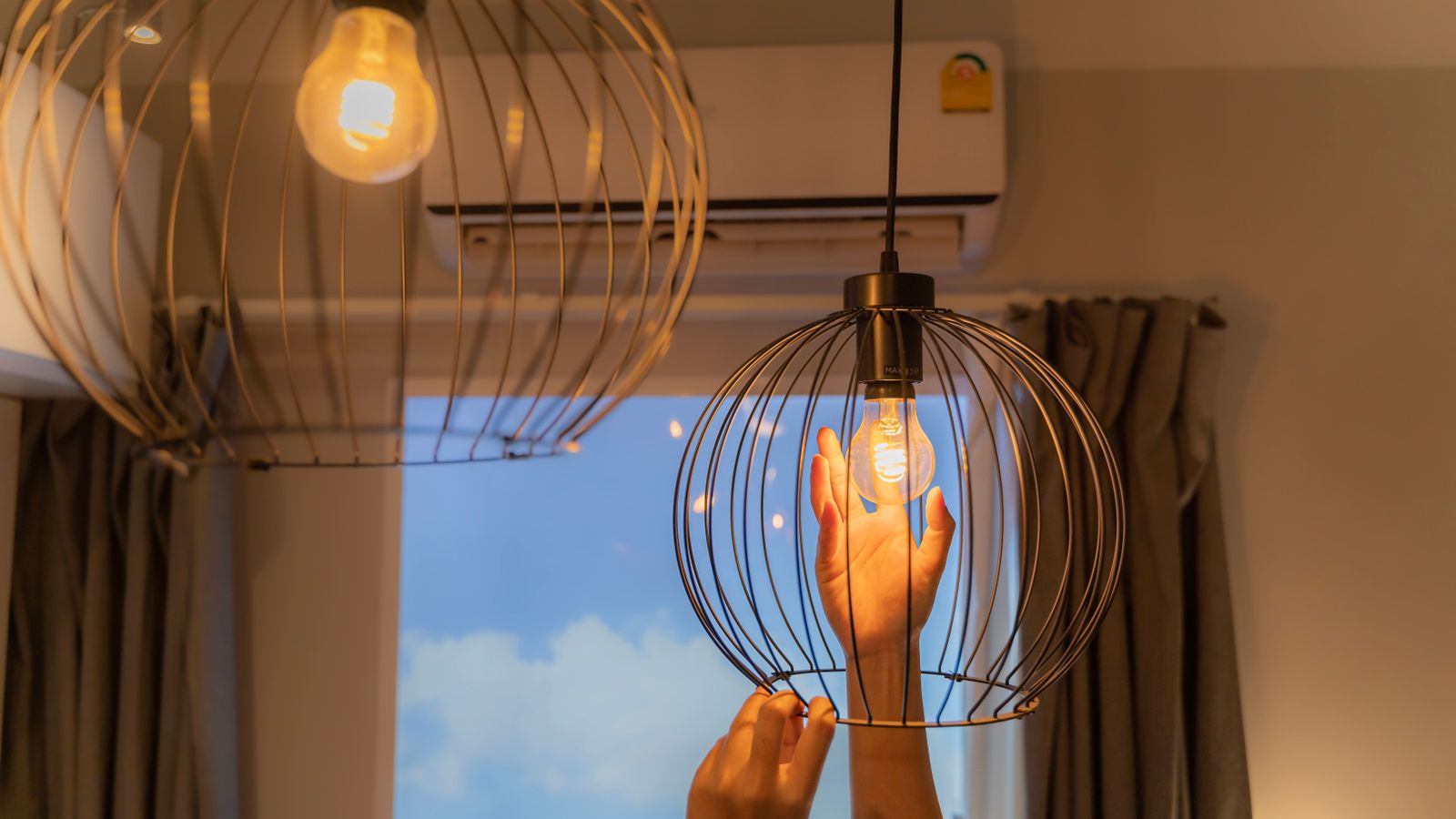 Una persona instal·la una bombeta de la llum