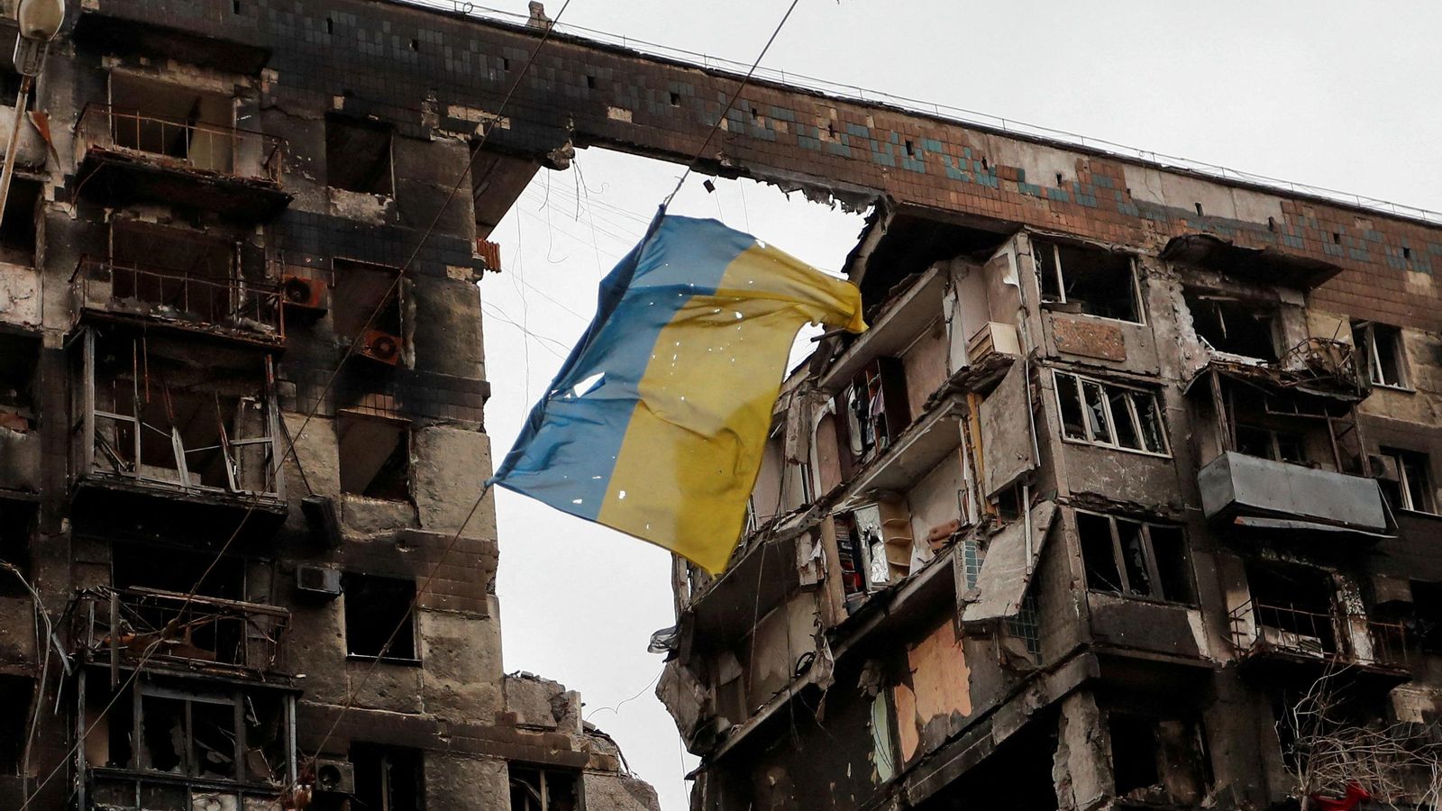 El vent sacseja una bandera ucraïnesa desplegada sobre les restes d'un edifici bombardejat a Mariúpol