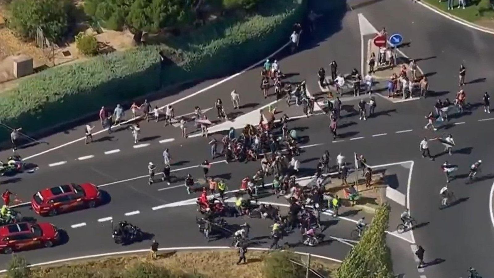 Un grup de manifestants intenta tallar el pas als corredors en la penúltima etapa de la Vuelta a Espanya
