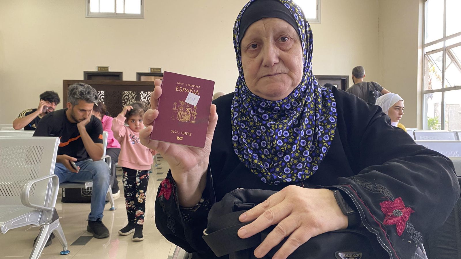 Una dona mostra el seu passaport espanyol mentre espera poder eixir de Gaza en el pas de Rafah