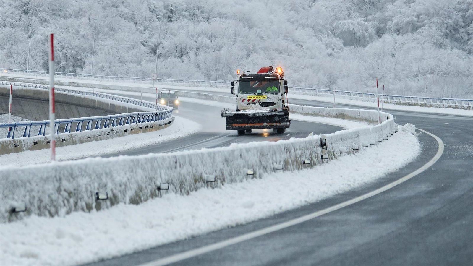 Un camió llevaneus avança per una carretera durant una nevada de l'any passat