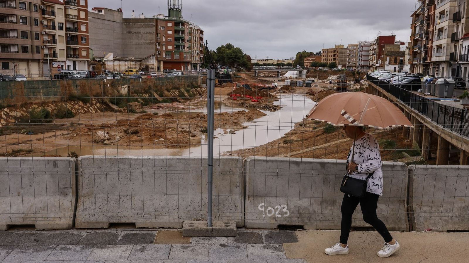 Una dona travesa el barranc de Poio per un pas habilitat