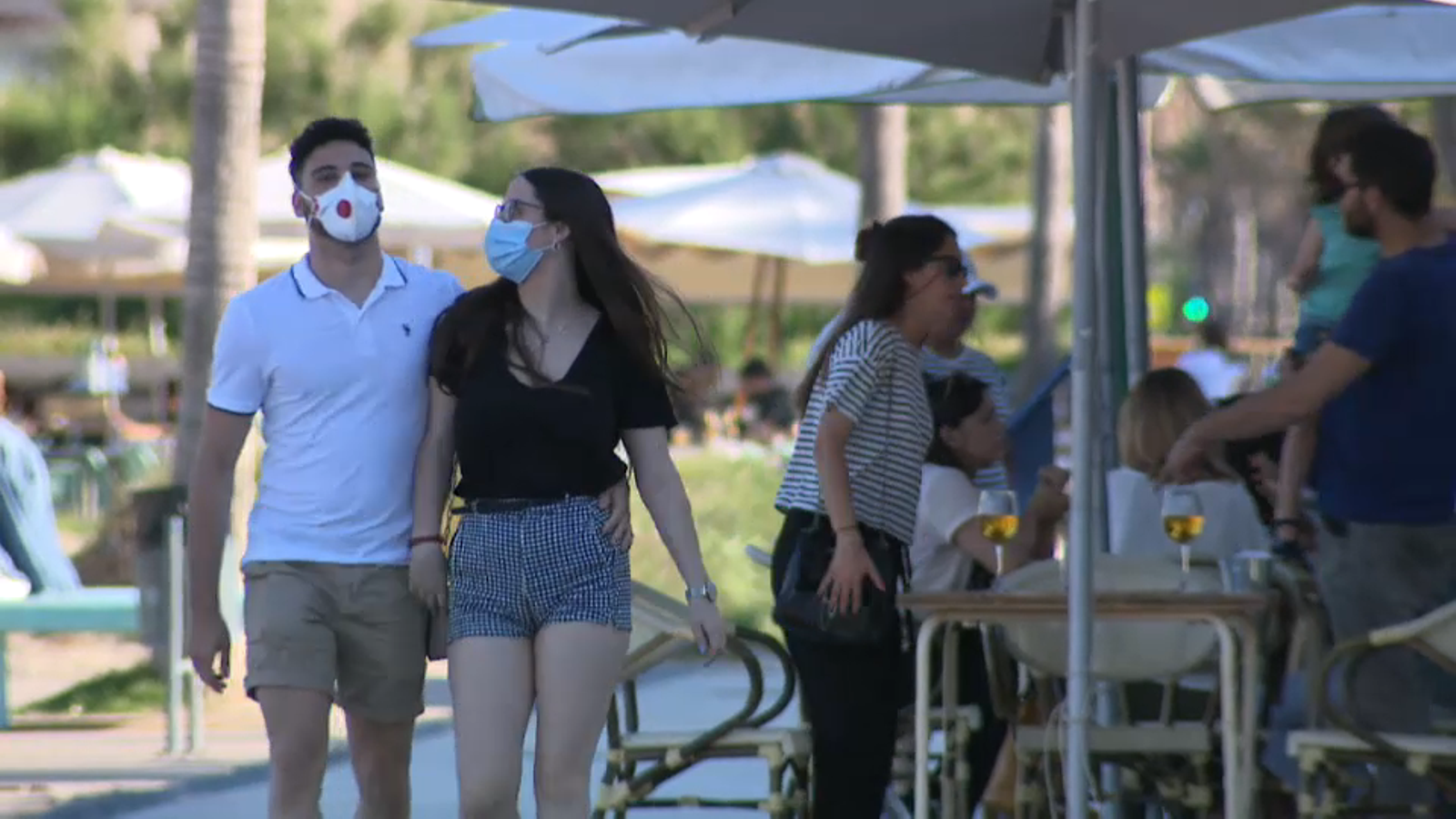 Dues persones caminen pel passeig marítim de València