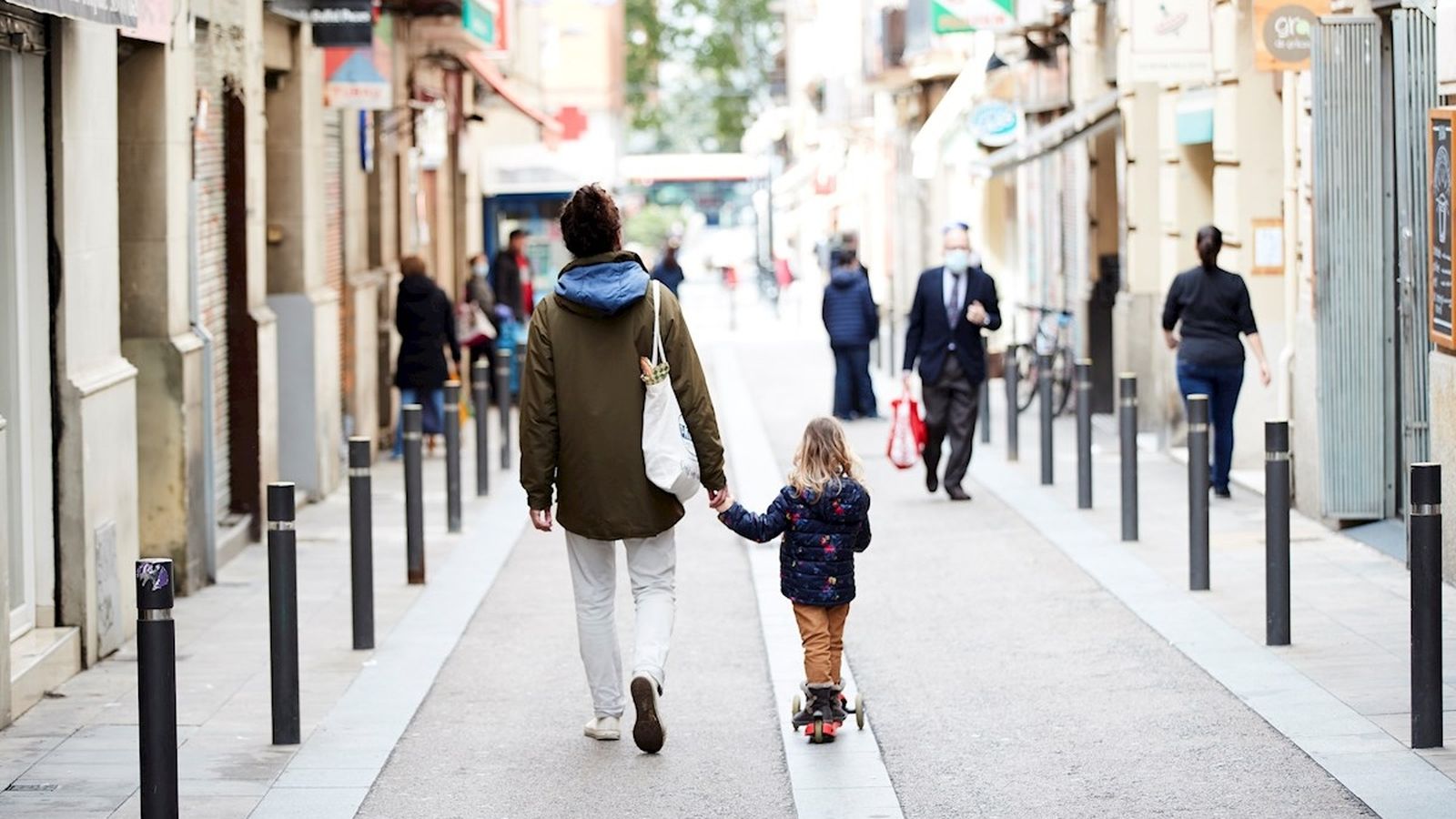 Un pare i la filla caminen pels carrers de Barcelona