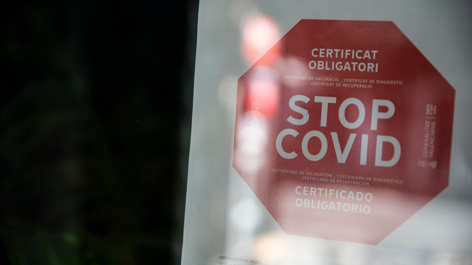 Un local a València mostra un cartell amb l'obligatorietat del certificat covid