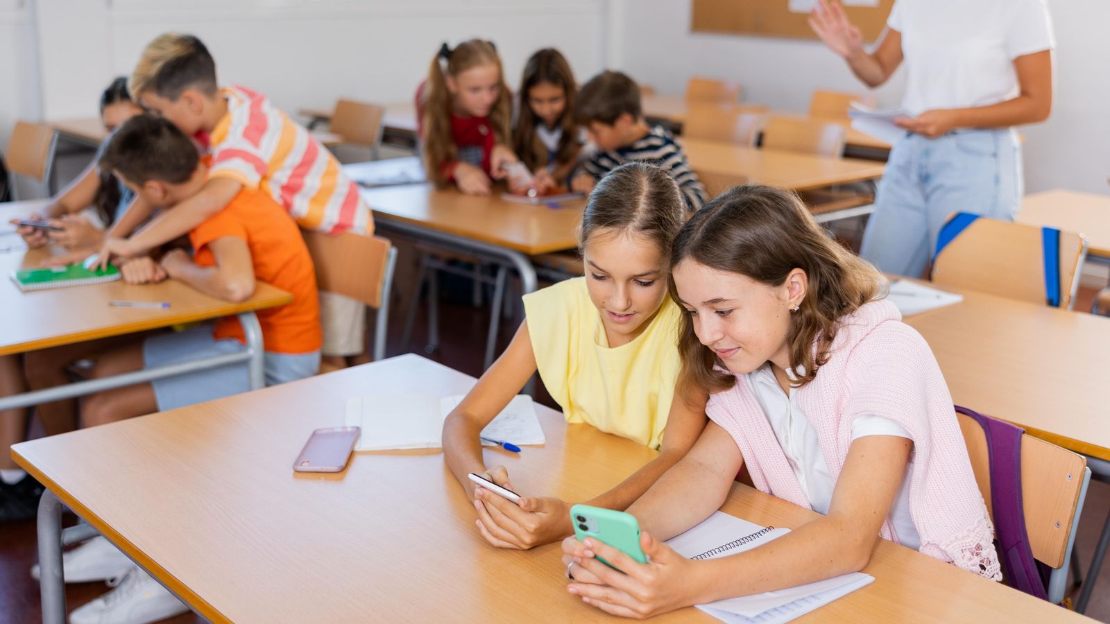 Alumnes d'un centre educatiu usant el móbil en classe