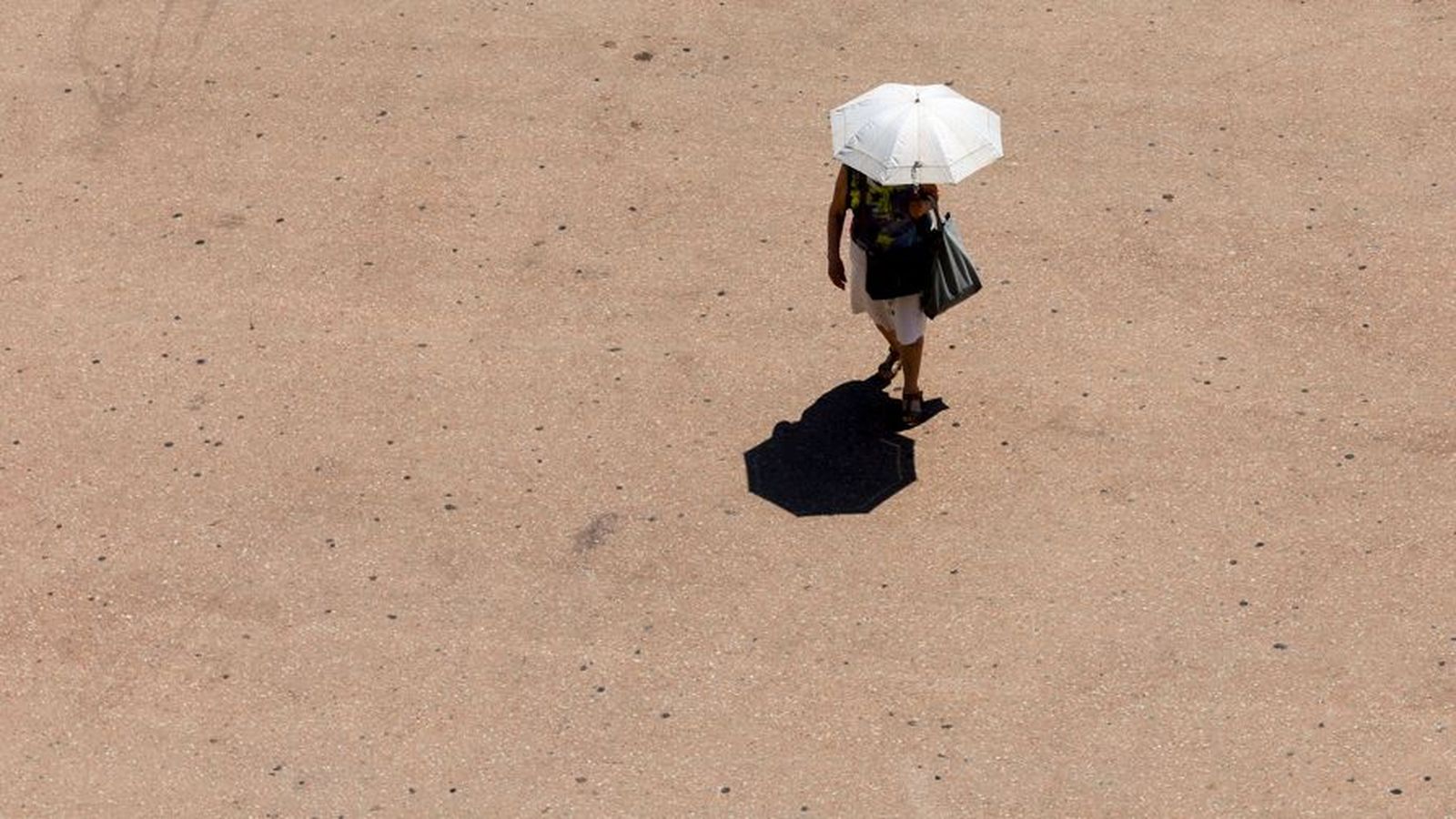 Una dona es protegeix amb un paraigües del sol a València