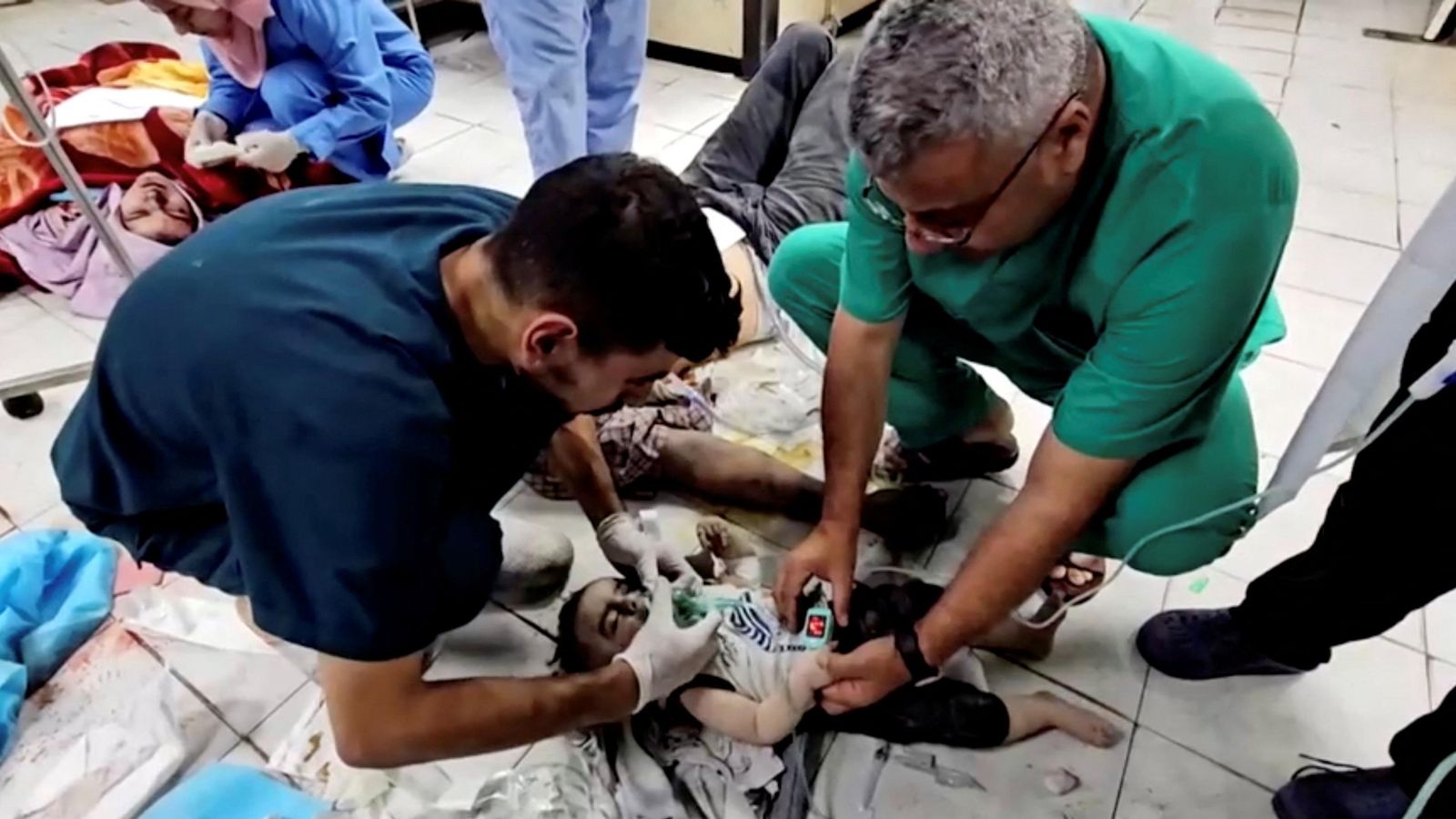 Dos sanitaris de l'hospital indonesi, que s'ha quedat sense electricitat, tracten de salvar la vida a un xiquet ferit en el bombardeig israelià del seu habitatge