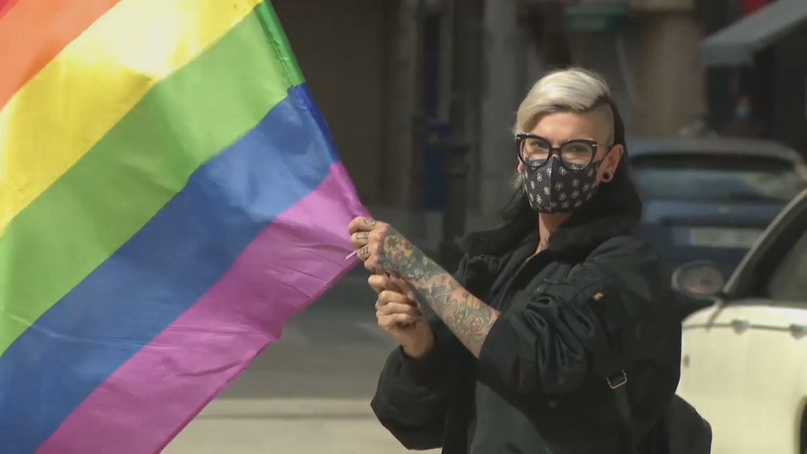 Una manifestant oneja la bandera LGTB a Alacant