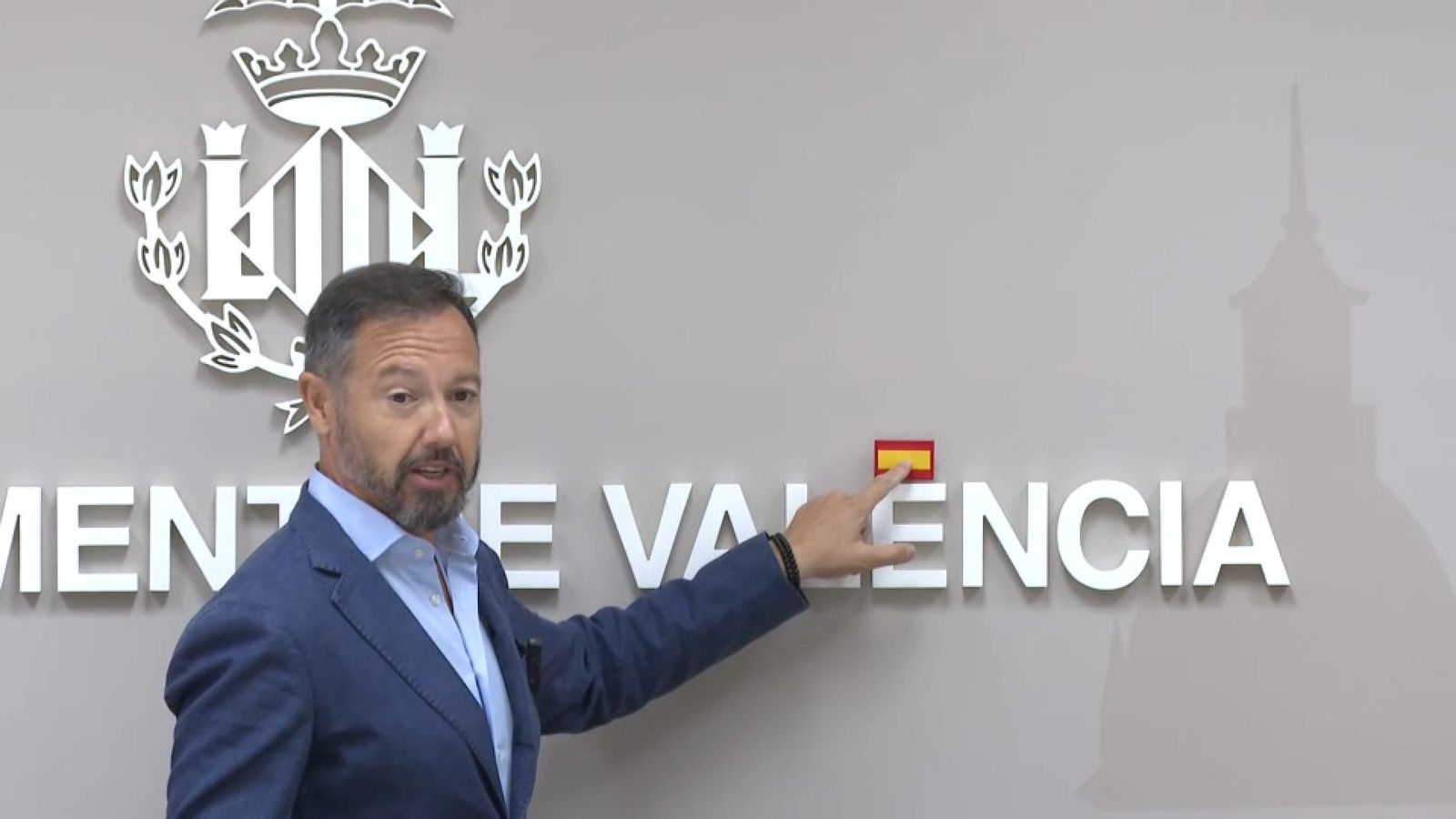 El regidor de Vox, Juanma Badenas, tapa amb una bandera d'Espanya la tilde de València