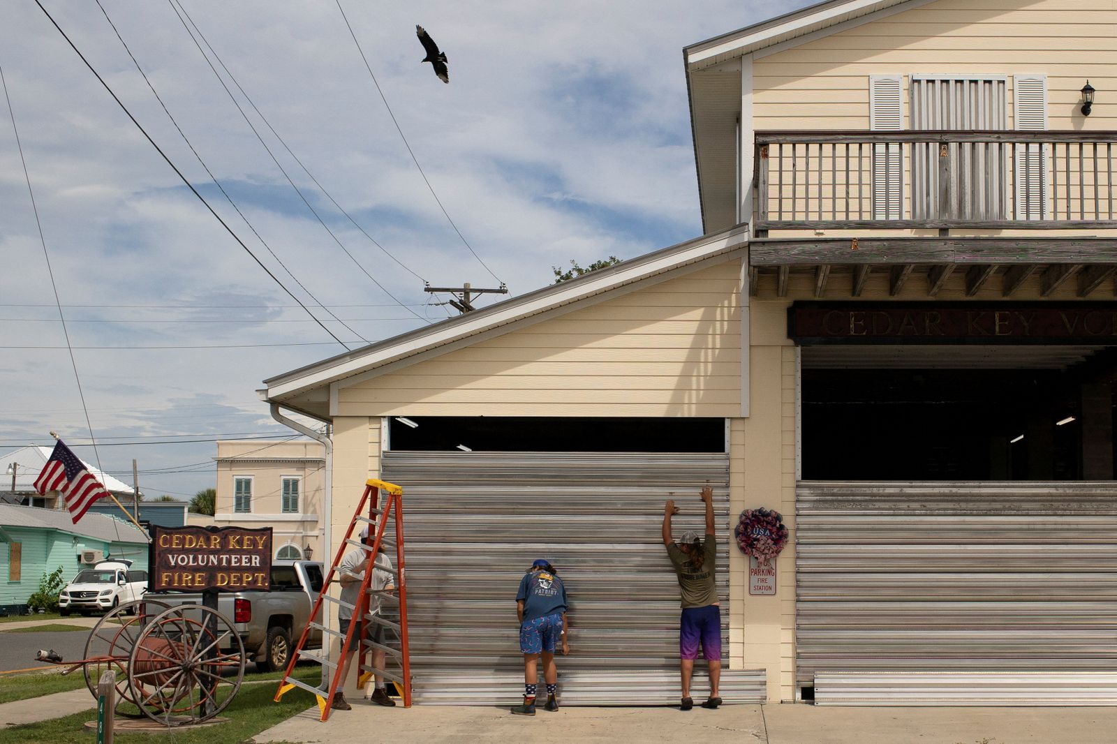 Voluntaris col·loquen persianes per a protegir l'estació de bombers de Cedar Key, Florida