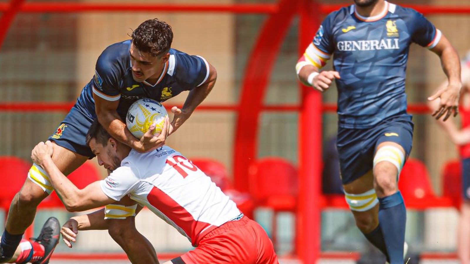 Un jugador de la selecció espanyola rep un bloqueig per part d'un jugador rival